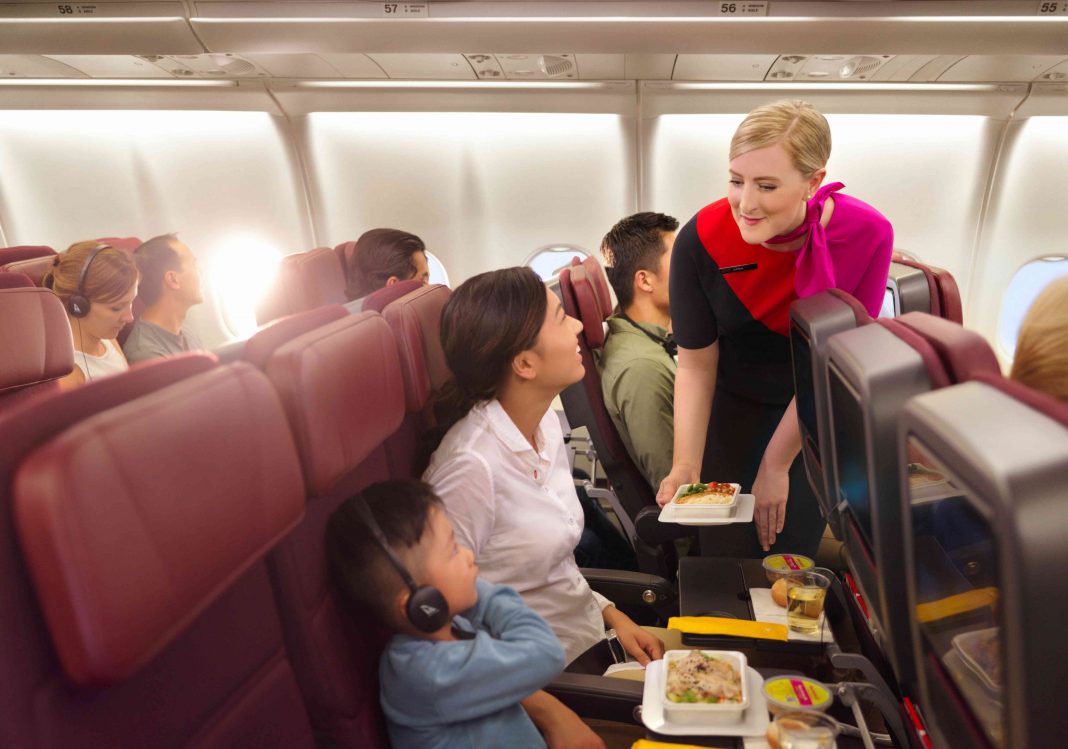 Showing Qantas air hostess providing customer service