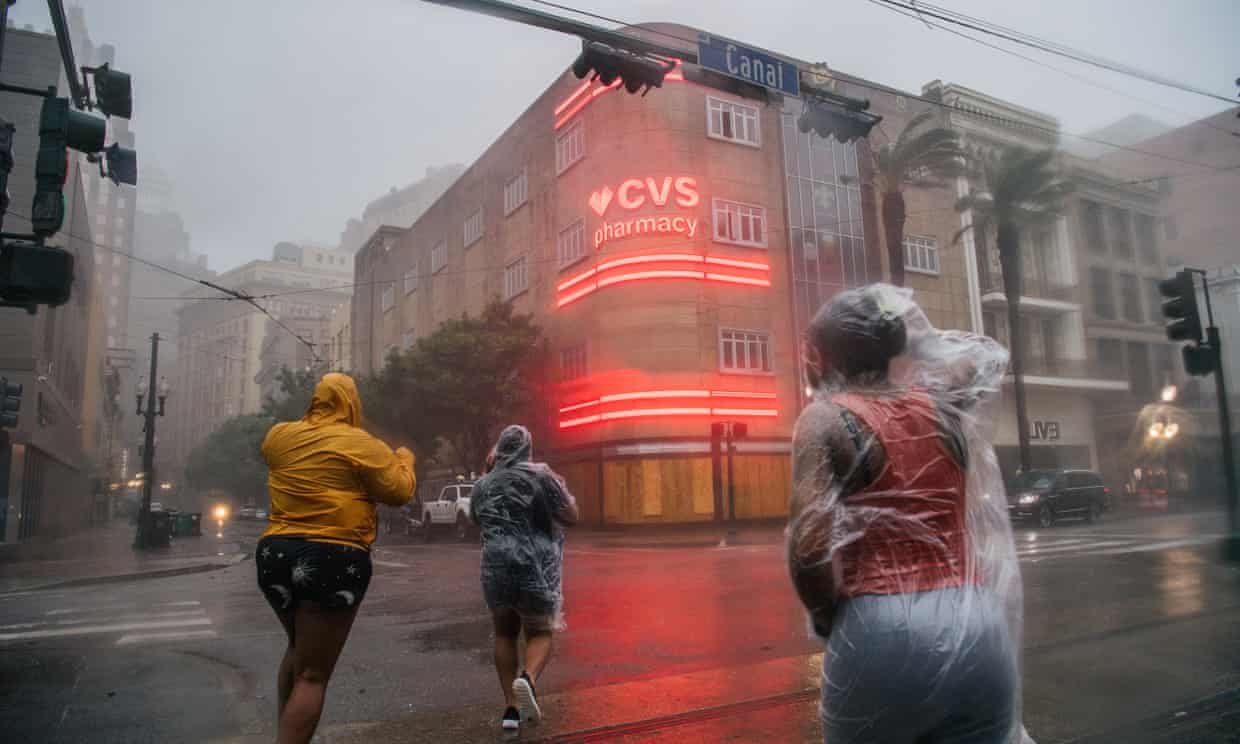 A group of people cross an intersection during Hurricane Ida on August 29th