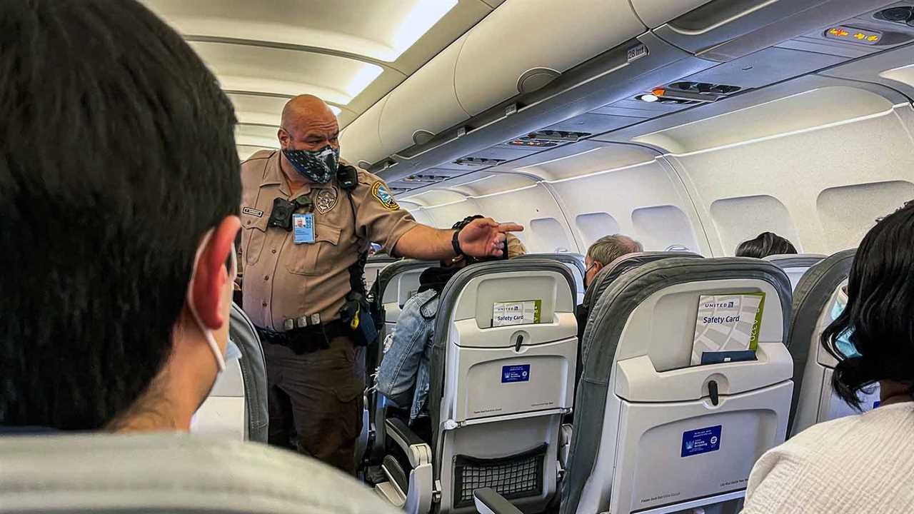 An officer from the Airport District Police of Miami International Airport gestures toward passenger Dontavious Jackson 