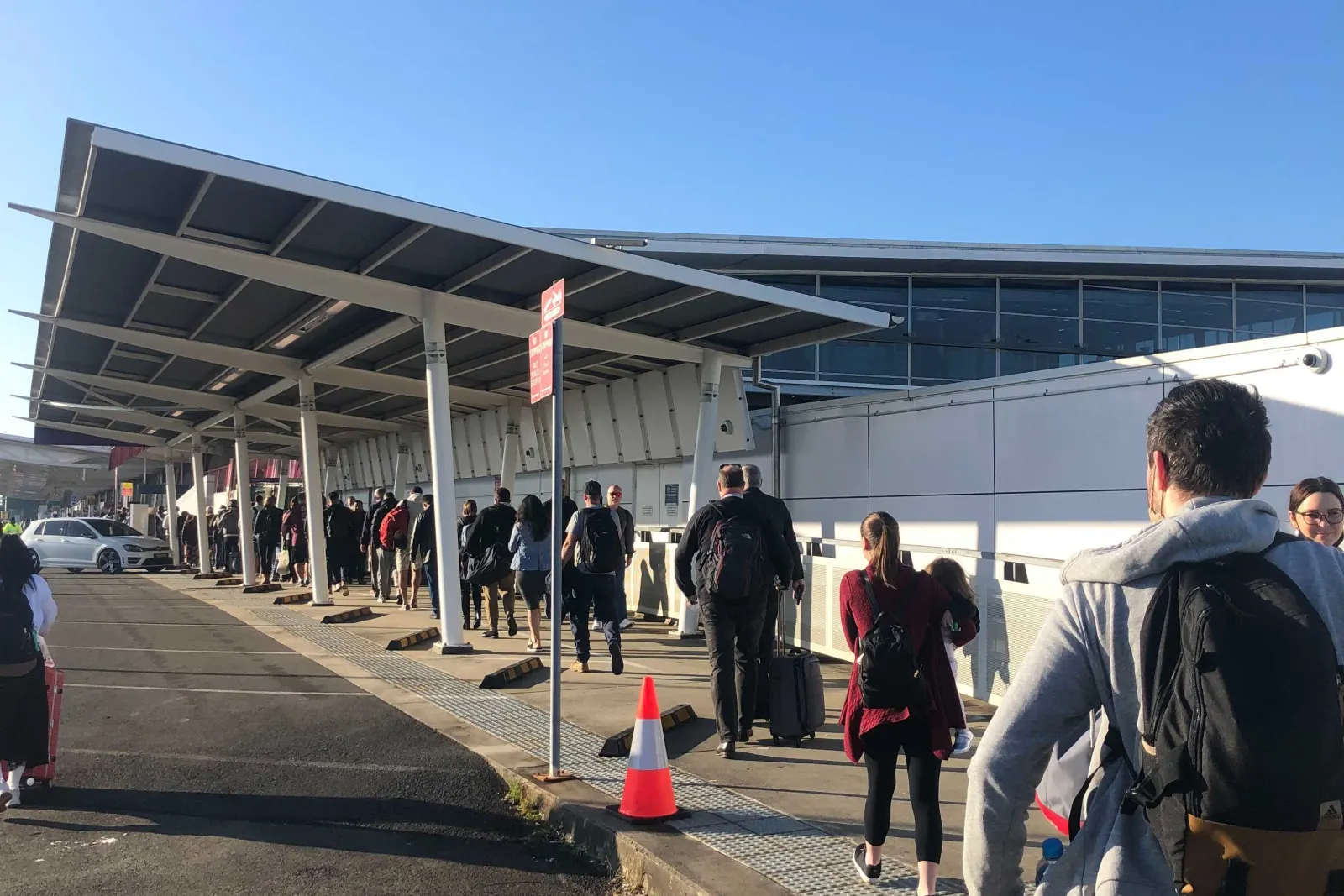 Passenger spill out the terminal entrance as they face delays