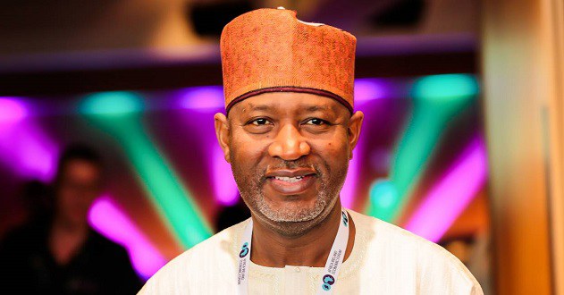 Aviation Minister Hadi Sirika stands smiling in front of coloured lights