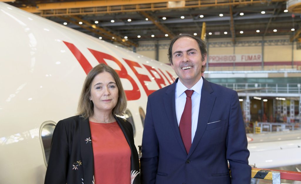 Marta Rivera de la Cruz and Javier Sánchez-Prieto stand smiling in front of Iberia aircraft.