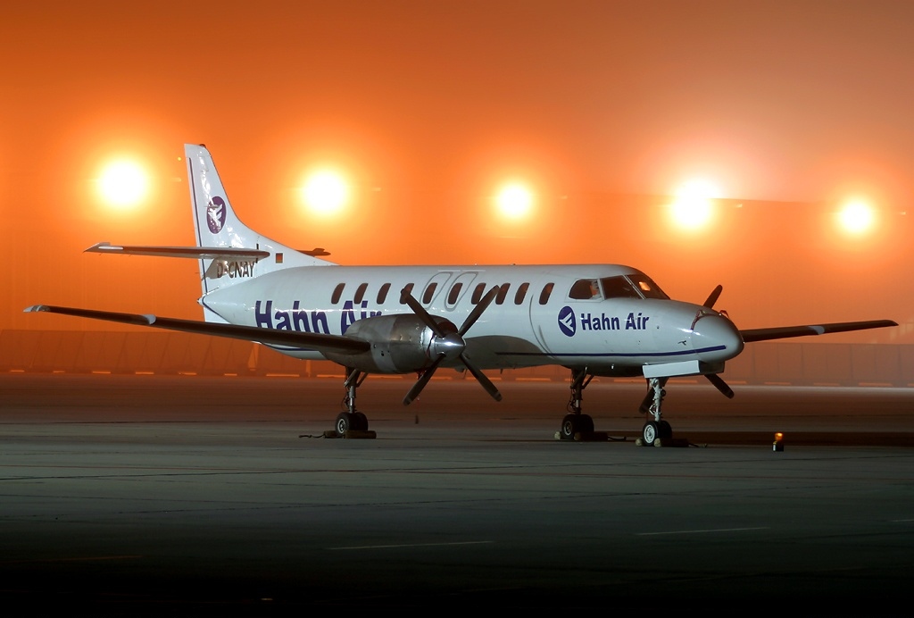 Hahn Air aircraft on runway. Five orange lights are visible in the dark