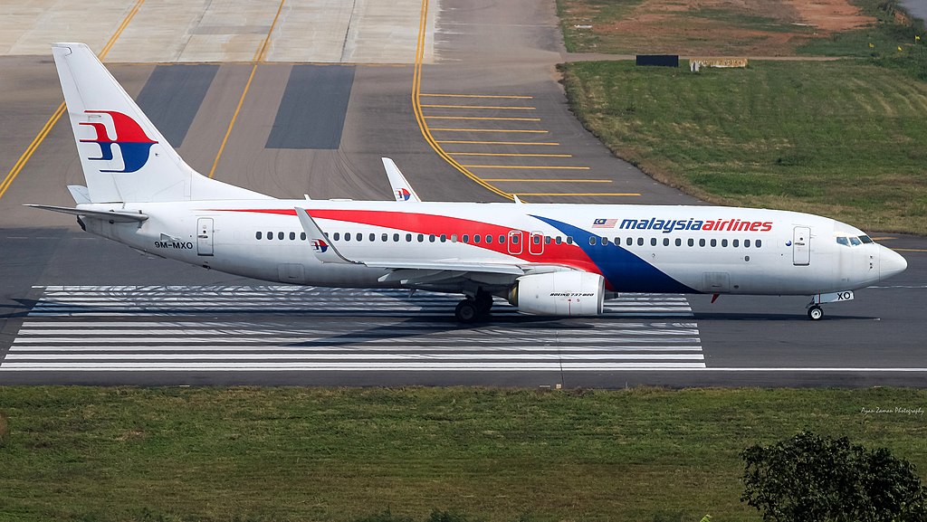 Profile view of Malaysia Airlines aircraft sitting on tarmac.