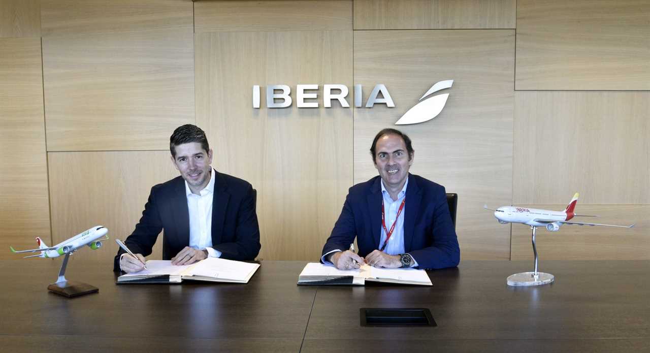 Iberia workers signing contracts with two model planes in the foreground.