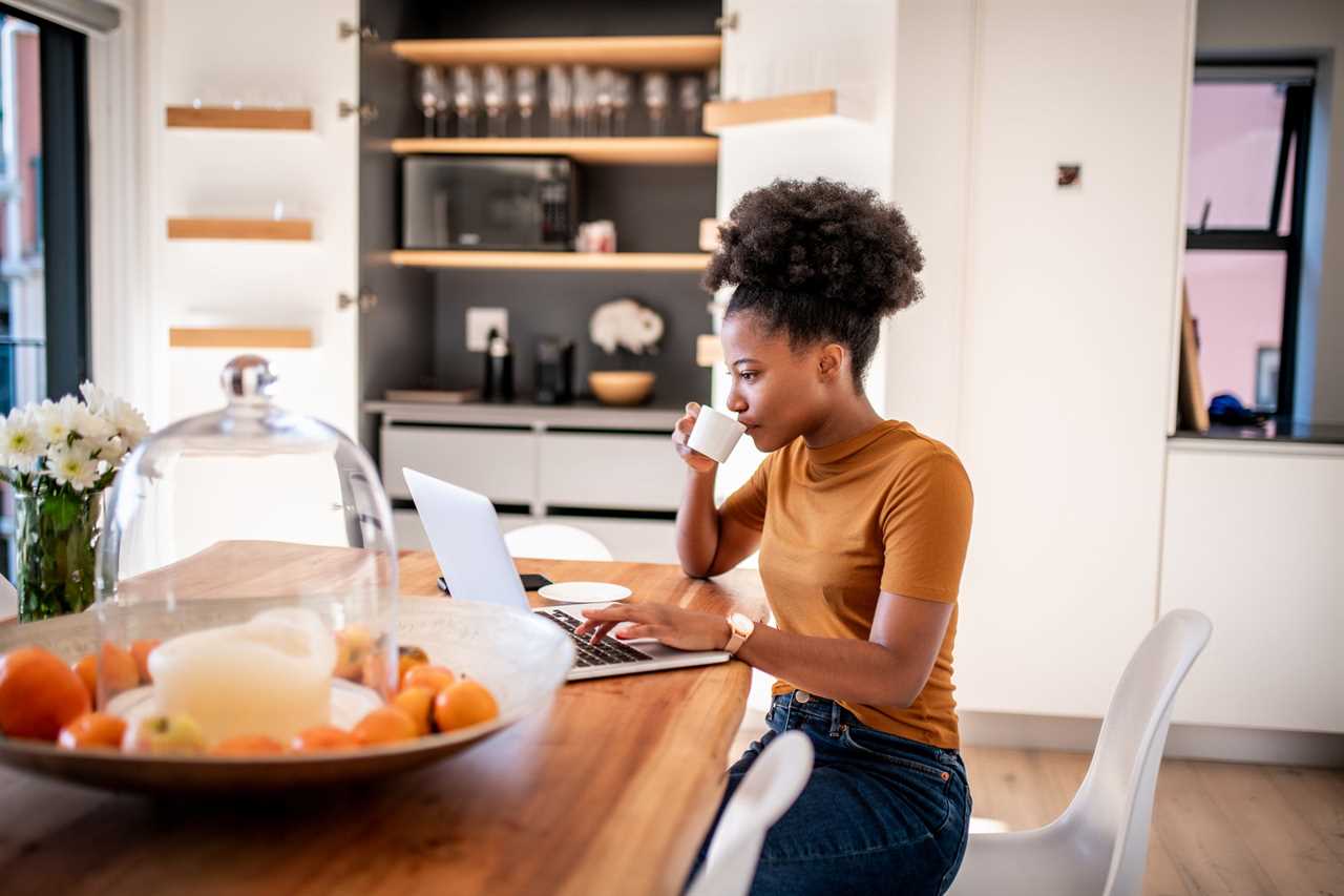 Young woman drinking coffee and checking the online shop