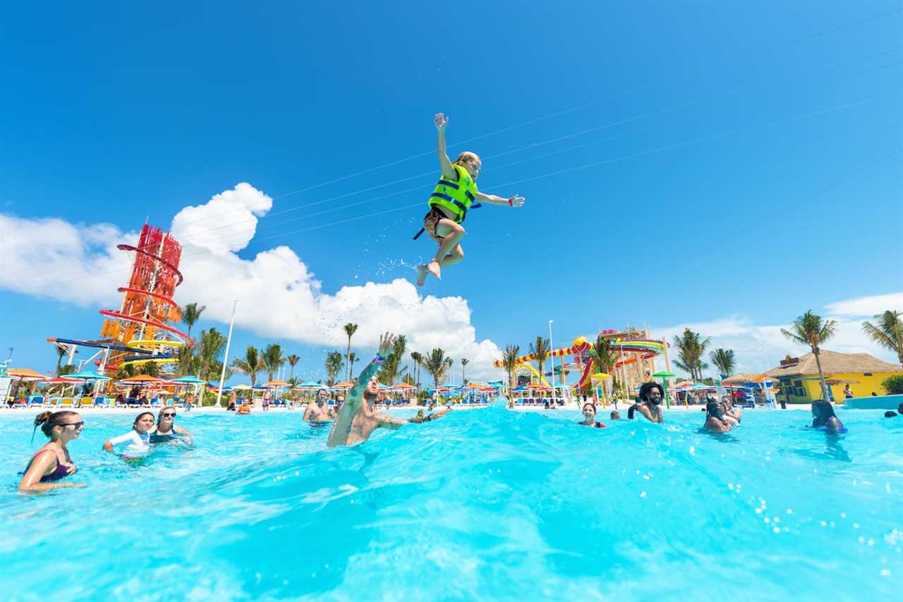 Families playing in pool with water park in the background