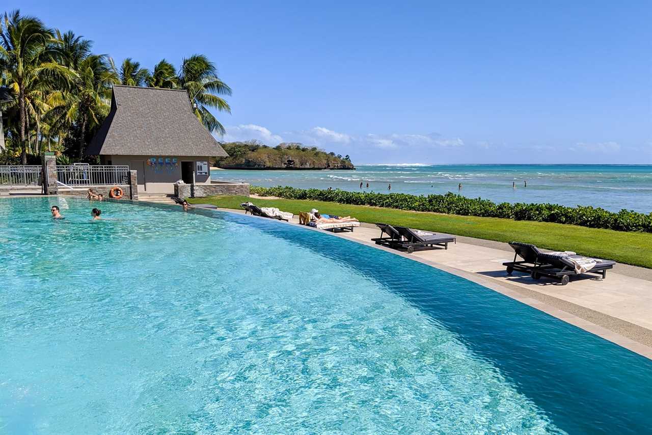 a hotel pool looks out over the ocean