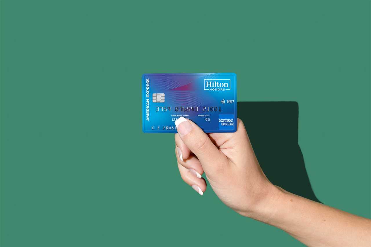 A hand holding a credit card