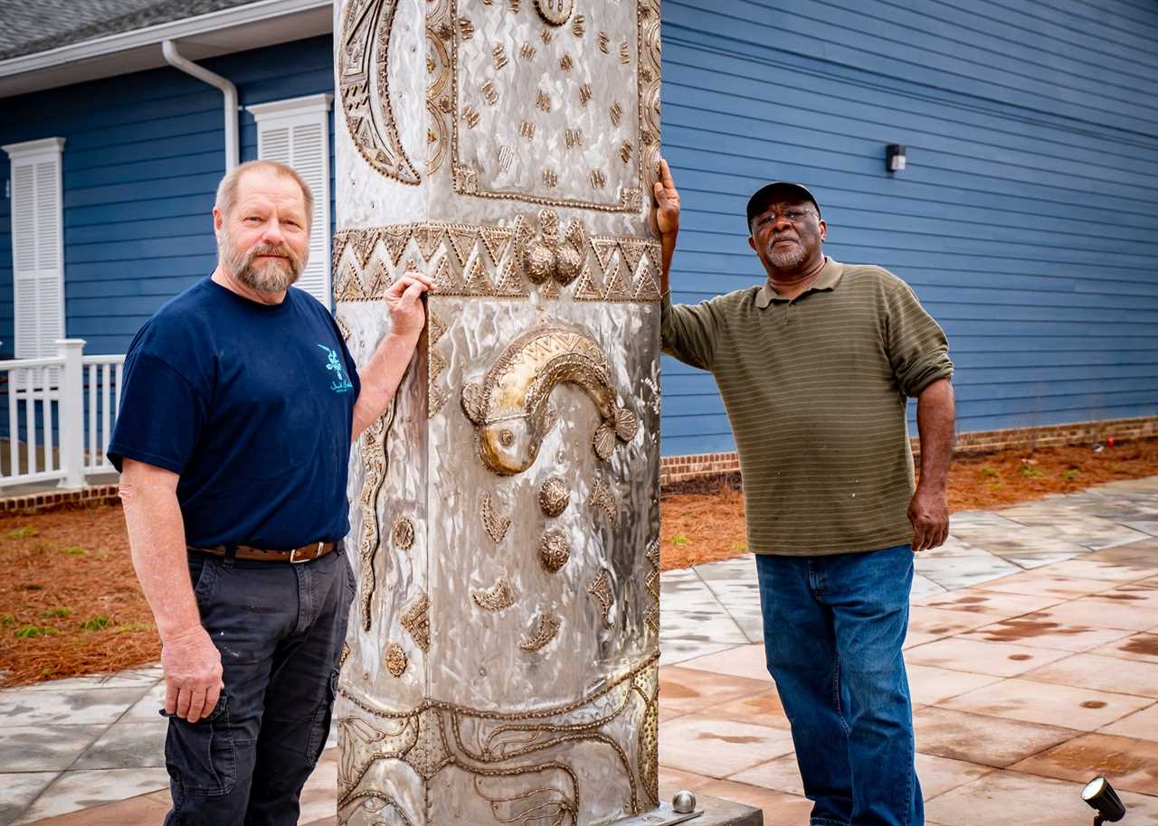 two men with a sculpture