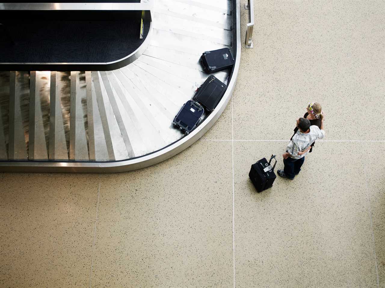 Couple waiting for luggage at baggage claim