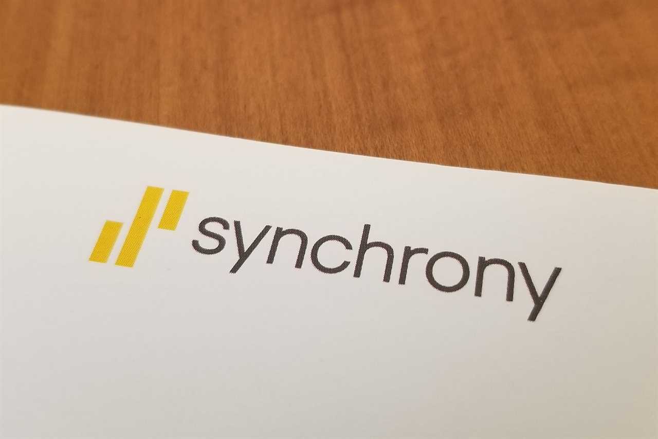 Close-up of logo for Synchrony Bank on a paper on a light wooden surface, July 10, 2019. (Photo by Smith Collection/Gado/Getty Images)