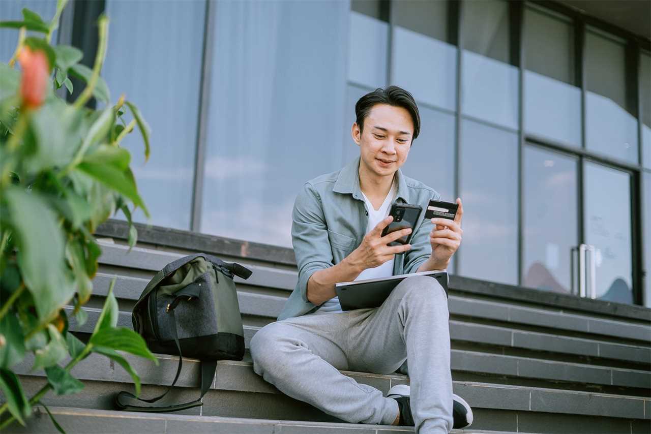 Man using a cell phone and tablet outside