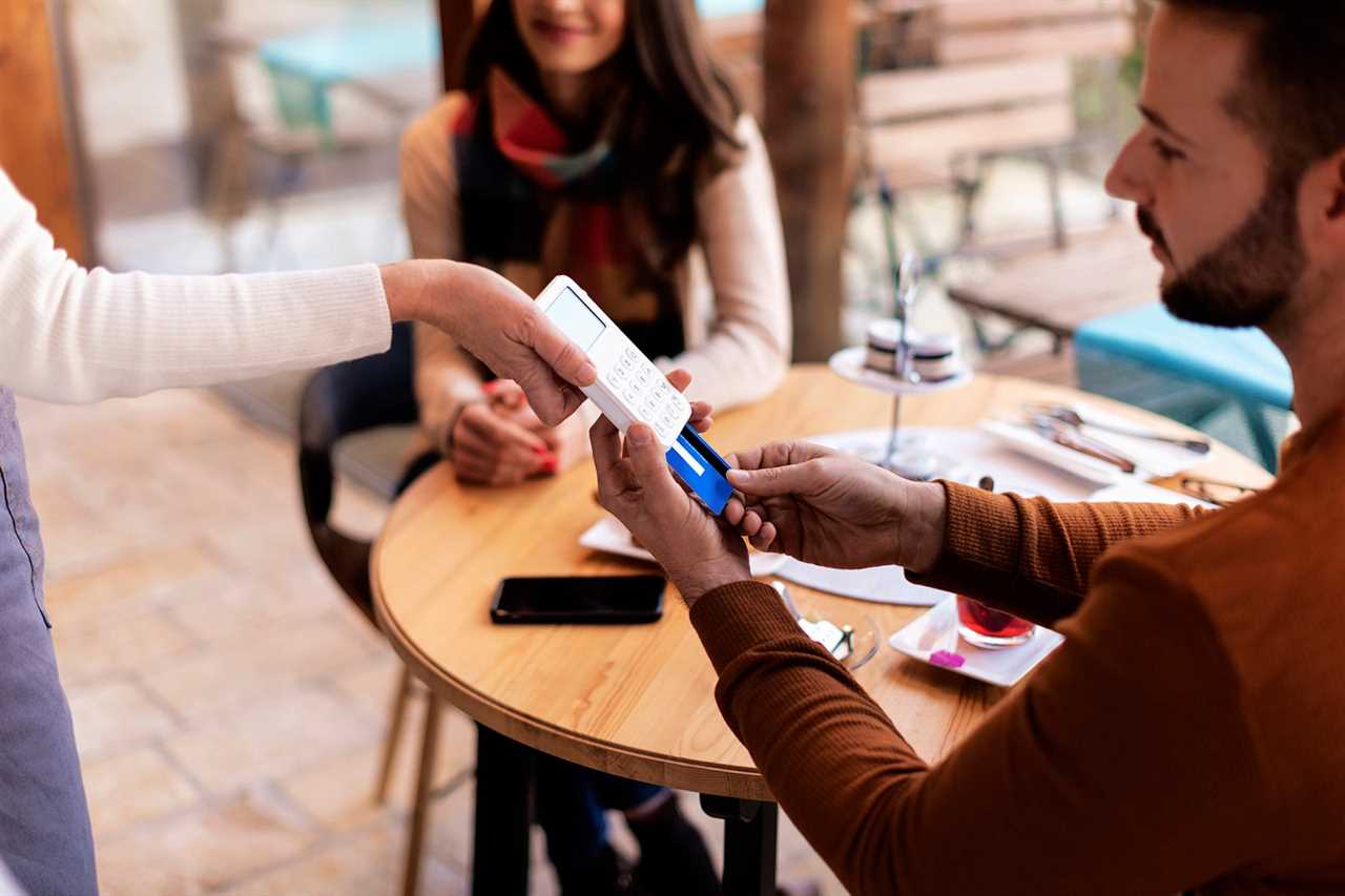 Close-up of a man man paying with card in a cafe