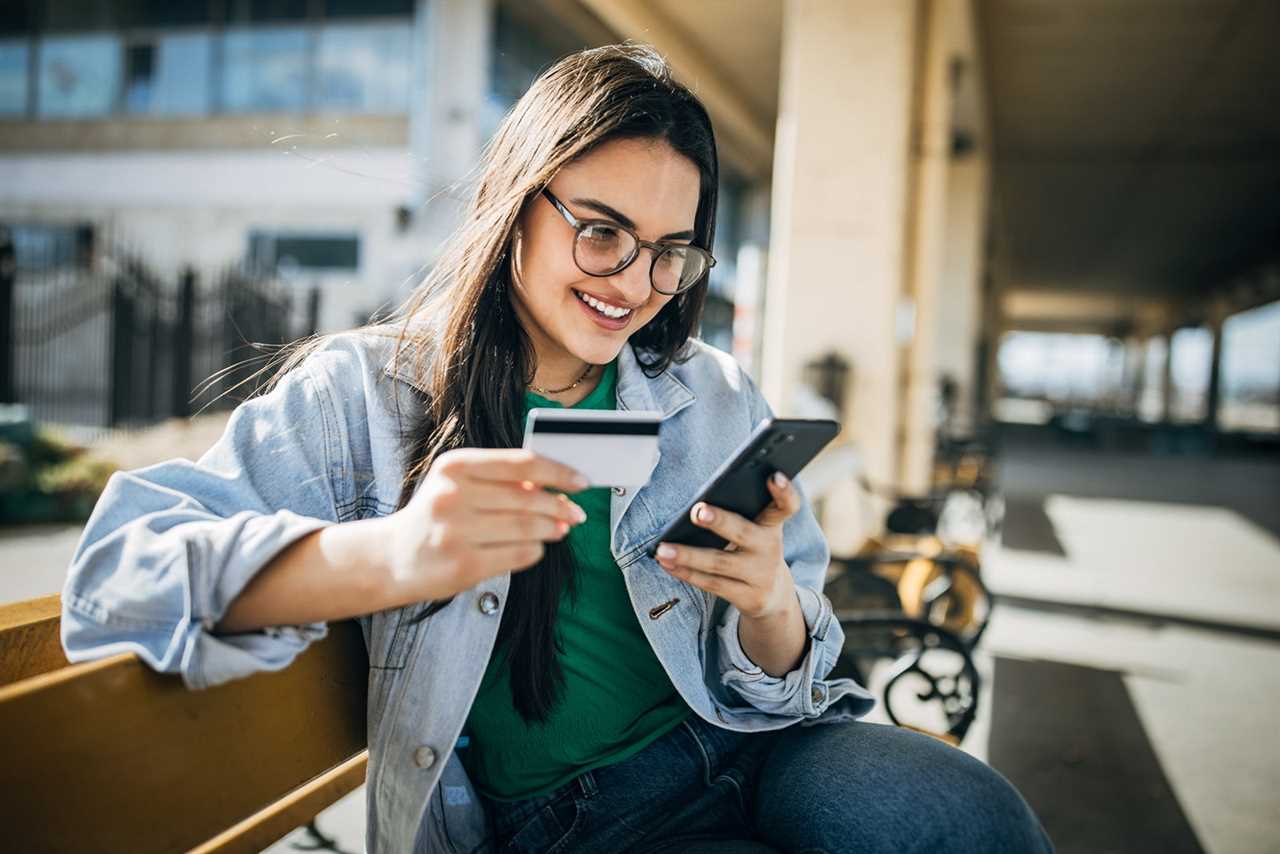 Young woman online shopping at home on mobile phone n the railway station