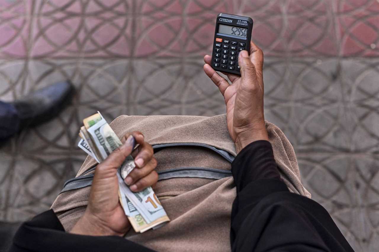 Person holding money and a calculator