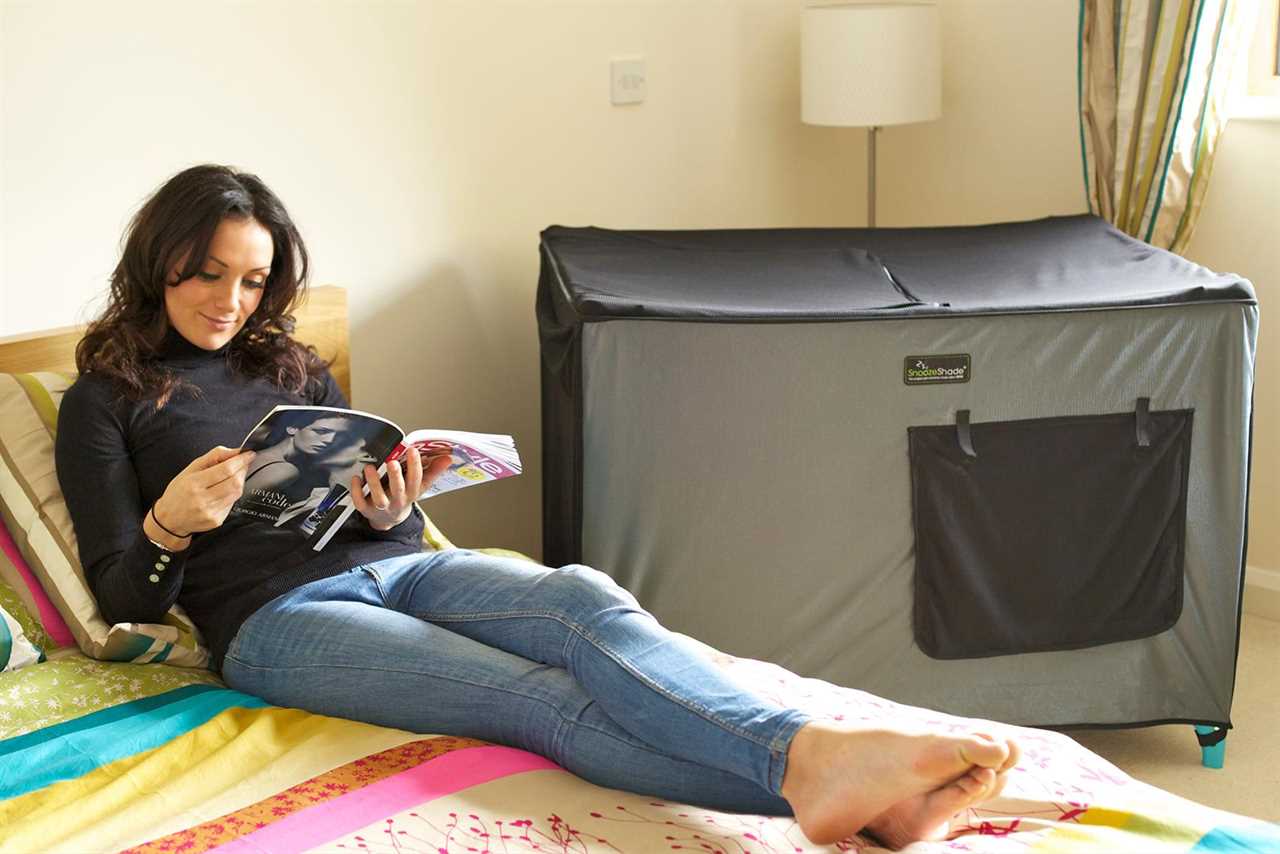 Woman reads magazine beside a Pack n' Play