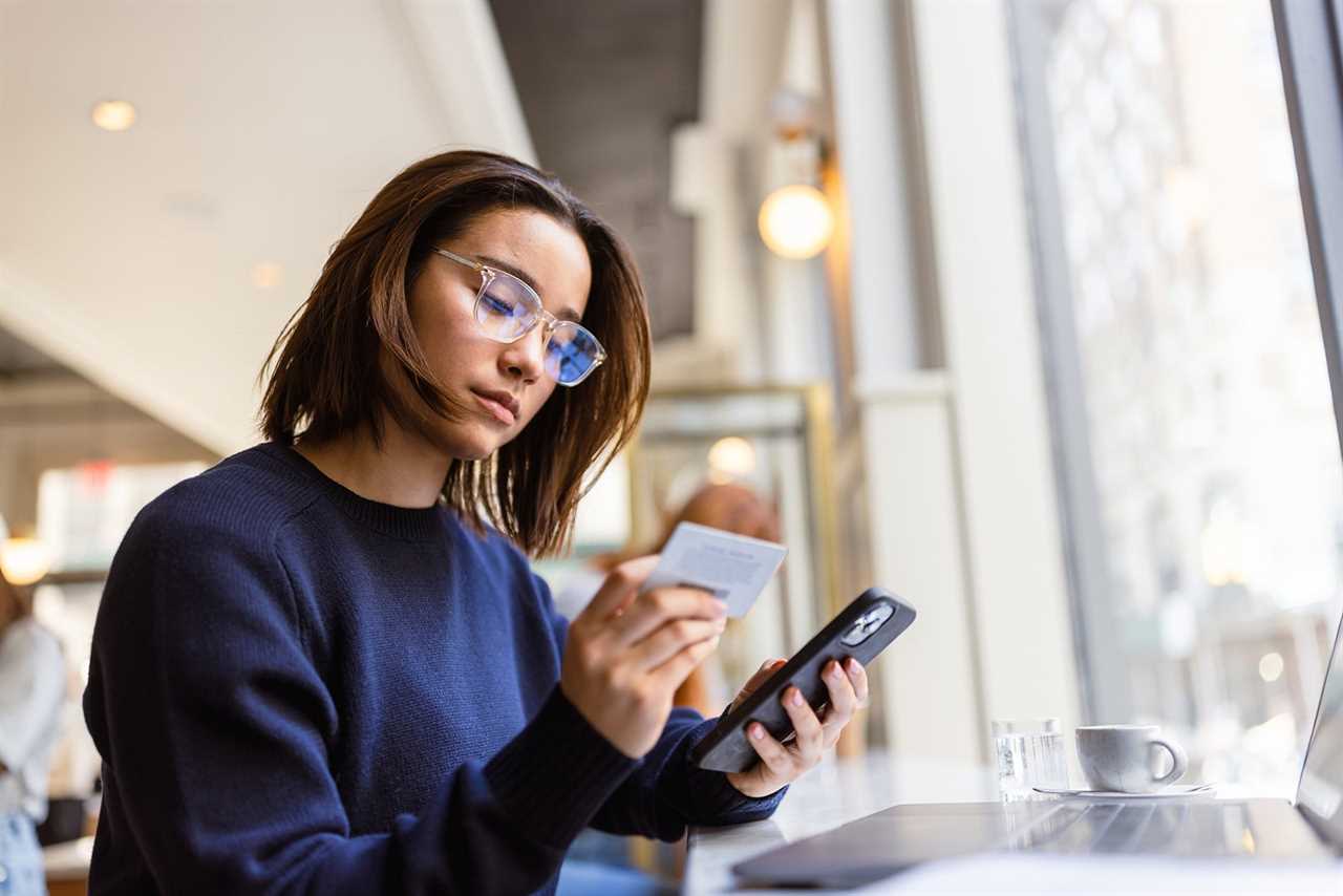 Woman holding a card and cell phone