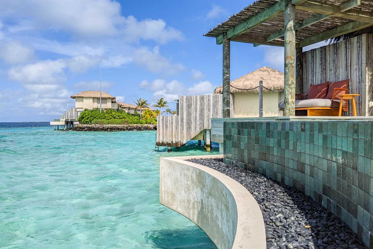 a luxury hotel with overwater bungalows on a sunny day