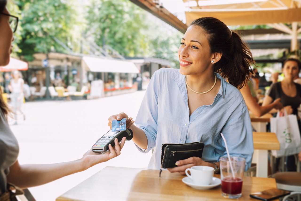 Woman pays with her card at a cafe