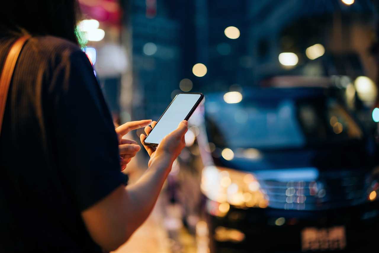 a ride share passenger checks the app