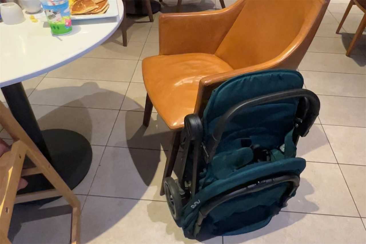 A foldable stroller attached to a chair 